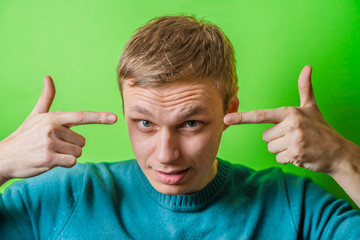 young man gesturing with fingers against his temple, are you crazy?