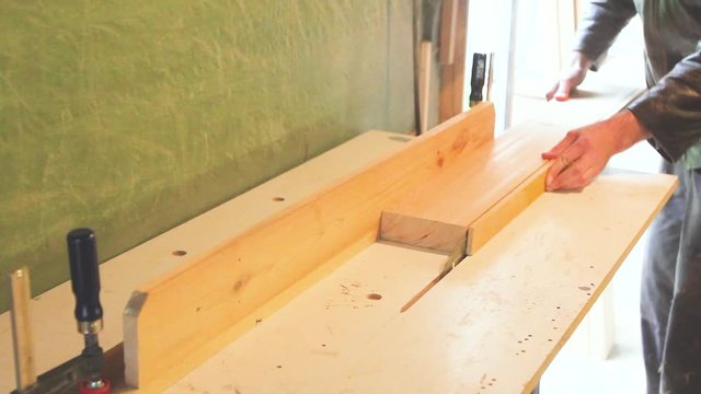 Carpenter works on circular saw, woodworking machine in the carpentry workshop 