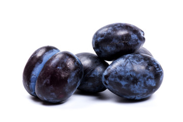 Fresh blue plums, isolated on white background, in close-up.