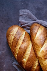 Fresh loaf on a brown background.  Traditional wheat freshly rustic baked bread, loaf of bread.