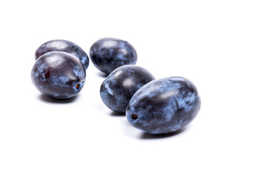 Fresh blue plums, isolated on white background, in close-up.