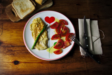 Tortilla francesa con esparrago triguero acompañada de una ensalada de tomate con sal, pimienta y  aceite de oliva