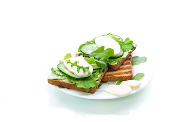 fried bread toasts with salad leaves, cheese spread and mozzarella in a plate