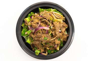 Top view of Spicy Grilled Beef Salad (Red onion, Spring onion,Rice powder, Lettuce Chili powder )in black bowl on white background.