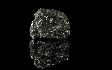 A cluster of pyrite crystals. Isolated on a black mirror background.