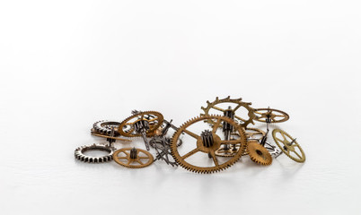 A bunch yellow metal gears of various sizes on a white background.