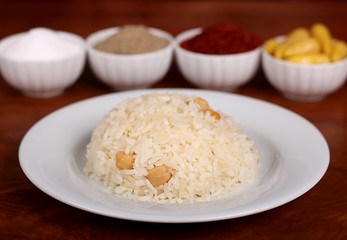 perfect turkish food chickpea rice spicy on white plate on wooden table close up