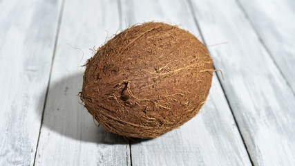 Dojrzały orzech kokosowy na drewnianym stole rustykalnym © piotrszczepanek