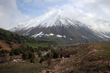 Fototapeta premium Too Ashuu mountain pass scenic view by spring with white peaks, Kyrgyzia