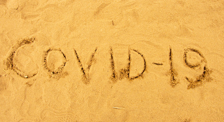 Inscription on the sand covid-19
