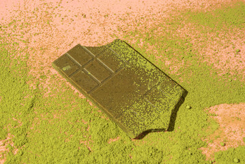 Green chocolate and powder matcha tea on pink background