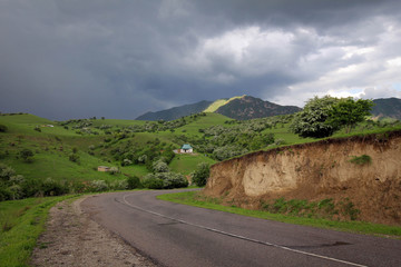 Scenic road view of green valleys and Tian Shan range, Central Kyrgyzia