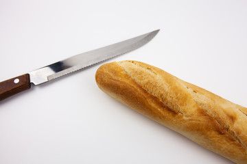 Freshly baked bread on a white background along with a knife for cutting fresh bread. For the presentation of food products, bread production and basic necessities.