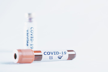 Test tube with positive covid-19 blood sample and bottle with vaccine.