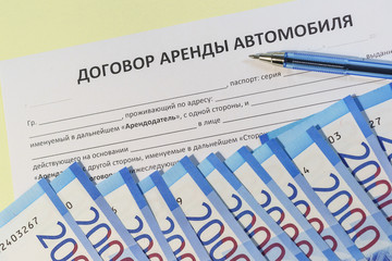 The signing of a bilateral agreement of renting a car from an individual. Russian rubles and the text 