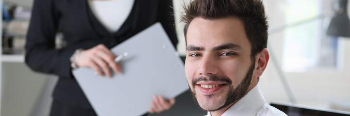 Handsome smiling businessman in suit portrait at workplace look in camera. White collar worker at...