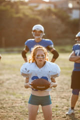 Obraz premium American football woman player in action on the stadium.