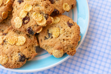 Group of cereal cookies in plate on table with tablecloth. Freshly baked oats biscuits.