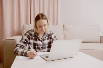 Young beautiful girl in checkered pajamas outlines a lecture.