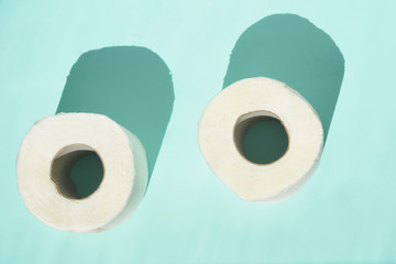 Toilet paper isolated on white table with blue background. Cleaning concept product photograph for advertising.