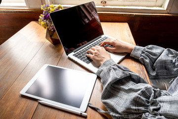 Business woman working at home with her laptop and tablat