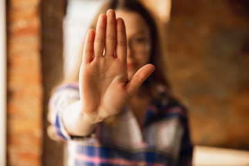 Close up view of young woman making stop gesture with her hand. Cropped isolated portrait of...