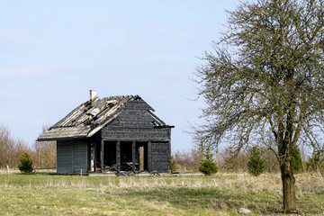 Fototapeta na wymiar burnt down two storey wooden house in rural area