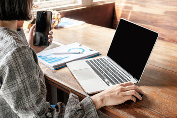 Business woman working at home with her laptop and phone