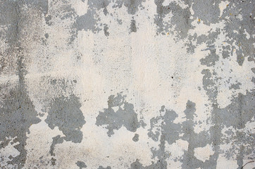 gray wall of old house closeup. White peeling plaster. Cracks on surface of building or fence. Weather aging buildings concept. Copy space. Place for text. Selective focus image.