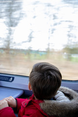 Fototapeta na wymiar a small boy looking at the window on a moving train