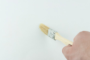 paint brush in hand on a white background