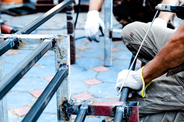 The mechanic is using a welding machine to weld steel