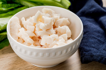Pork fat cut into pieces in a bowl on a wooden table