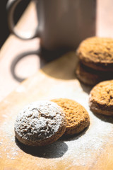 oatmeal cookies on a wooden board sprinkled with powdered sugar, toned