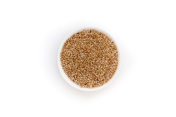 Bowl of uncooked buckwheat grains on white isolated background