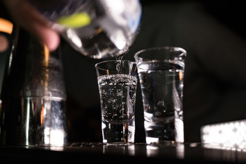 2 shots at the bar with sparks. Colorful footage in a nightclub. Alcoholic drinks with tequila. Nightlife scene. Shots at the bar table. Several glasses of alcohol