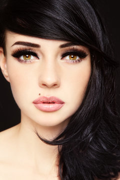 Close-up portrait of young beautiful woman with fansy makeup and false eyelashes