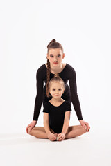 Obraz na płótnie Canvas Rhythmic gymnastics. Girl gymnast and trainer perform various gymnastic exercises. Children and sports, healthy lifestyle.