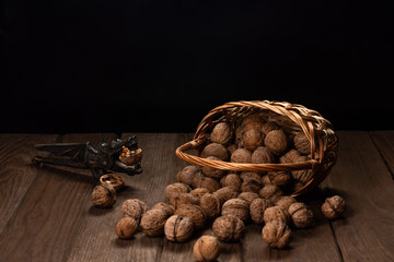 Nuts in a straw woven basket on a wooden table.
