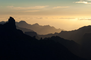 Roque Bentaiga to the left and cliffs of the west of Gran Canaria at sunset. Gran Canaria. Canary Islands. Spain.