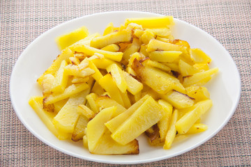 delicious fried potatoes on plate on white background