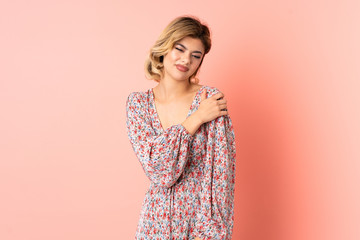Obraz premium Young Russian woman isolated on pink background suffering from pain in shoulder for having made an effort