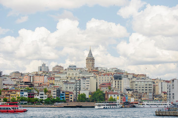 Fototapeta premium Galata Tower. View of famous historic landmark across Golden Horn. Popular tourist destination. Cloudy. Turkey, Istanbul, Bosphorus