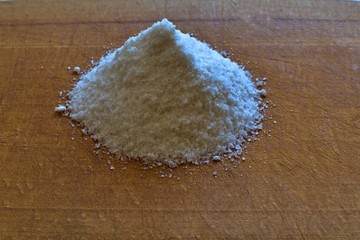 handful of salt on a wooden cutting board