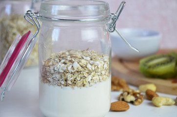 Healthy breakfast overnight oats with fresh berries in a glass jar with dried fruits, apple and nuts, walnuts, almonds. with yogurt, cottage cheese, pudding. diet, keto diet