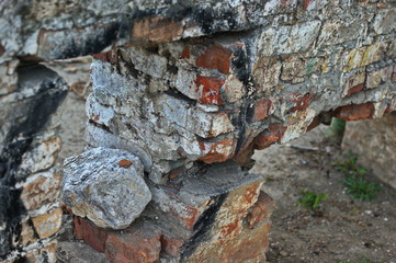 Destroyed brick walls of houses with rusty iron structural elements