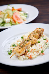 chicken kebab with rice and vegetables on the wooden background