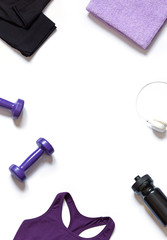 Sport flat lay with sportswear, a shaker, dumbbells and headphones on the white background. Home training concept top view. Copy space