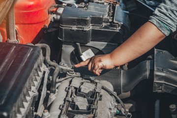 Little child trying to fix broken real car. Dreaming to be auto technician. Close up under the hood of a car