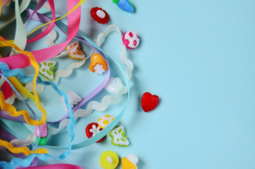 cotton ribbons and buttons against a mint color background with copy space